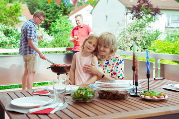 Happy big family having fun and enjoy their talk with children during grilling at terrasse