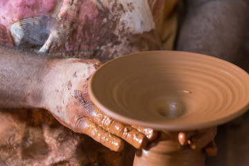 Producing the handmade pottery with hand on pottery wheel.