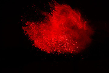 Abstract of red powder explosion on black background. Red powder splatted isolate. Colored cloud....