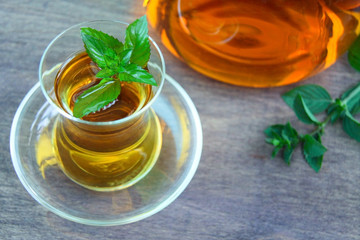 Fresh healthy peppermint tea in a transparent glass. Green mint leaf. Organic.