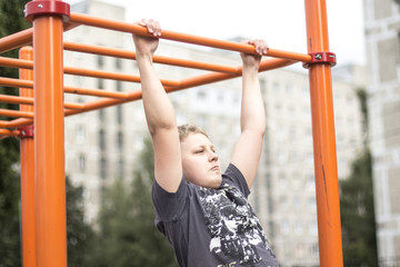 Fototapeta premium a boy with blond hair is engaged in the Playground