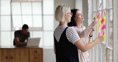Young adults planning in a creative office with adhesive notes