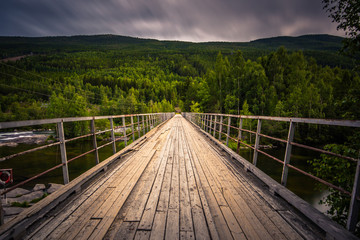 Fototapeta na wymiar A bridge crossing a river in the countryside of Norway