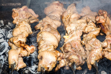 Grilled kebab cooking on metal skewer closeup. Roasted meat cooked at barbecue. BBQ fresh beef meat chop slices. Traditional eastern dish, shish kebab. Grill on charcoal and flame, picnic, street food