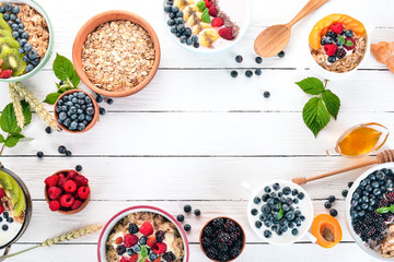 Large Assortment of porridge with fruit and berries. Breakfast. On a white wooden background. Top...