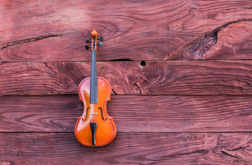 Naklejka premium violin on a red wooden background