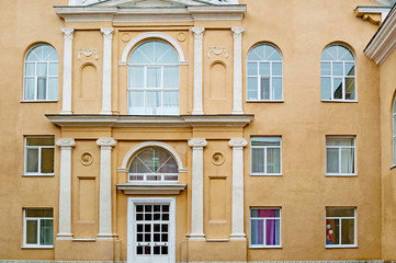 Fragment of the facade of a stylish building with beige walls, front view.