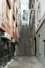 Fototapeta na wymiar A steep staircase between the walls.