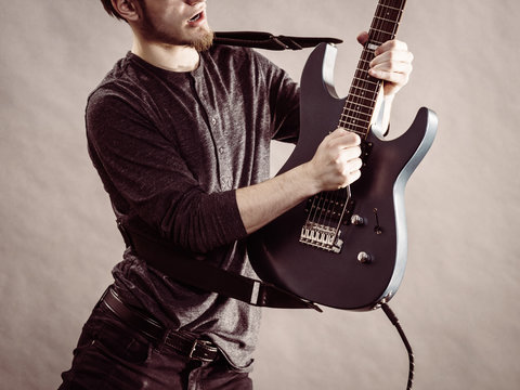 Young man playing electric guitar