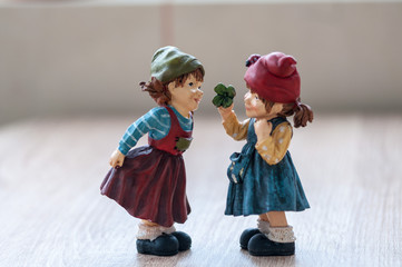 Close-up of two garden gnomes on a wooden table. Gnomes talking