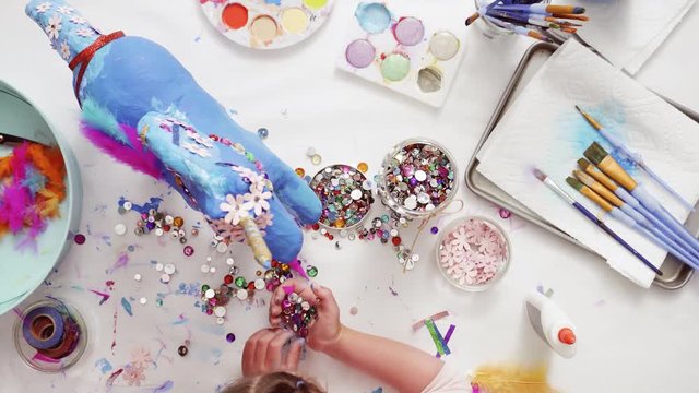 Step by step. Decorating painted paper mache unicorn with paper flowers and jewels