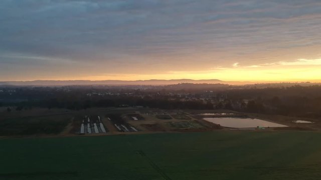 180 deg drone shot of a tyipical morning in Australia in a farm and suburbs.