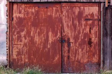 Old, rusty red double door, securely closed
