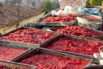 Perspective traditional handmade tomato and pepper paste making process at sunset time