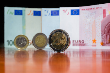 Close Up Euro Money Banknotes And Coins. cash Background. Money Bills With Reflection On The Table In Vertical Position. Finance And Economy Concept. Selective focus.