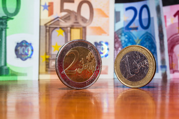 Close Up Euro Money Banknotes And Coins. cash Background. Money Bills With Reflection On The Table In Vertical Position. Finance And Economy Concept. Selective focus.