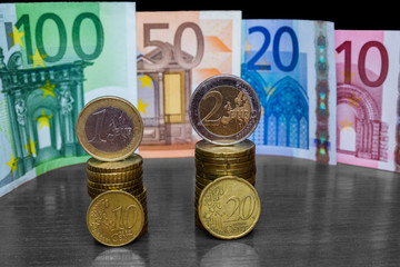 Close Up Highlighted Euro Money Banknotes And Coins Stacked On Each Other In Vertical Position. cash Background. Money Bills. Finance And Economy Concept. Selective focus.