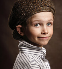Portrait of a beautiful little stylish boy in a cap.
