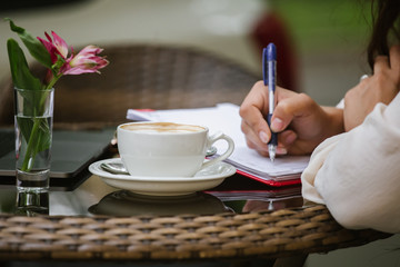 A cup of coffee standing on a table in an open-air cafe