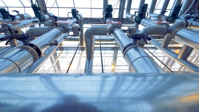 Close up of metal tubes, modern pipeline inside a factory facility.