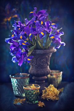 Still life with a beautiful bouquet of a purple irises on a table.