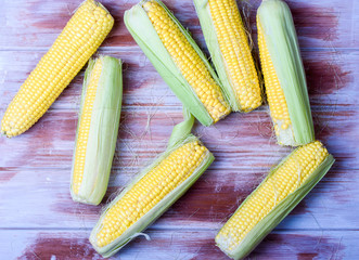 Ripe and sweet corn on a wooden background