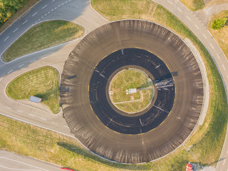 Aerial view of black round asphalt surface in evening sunlight