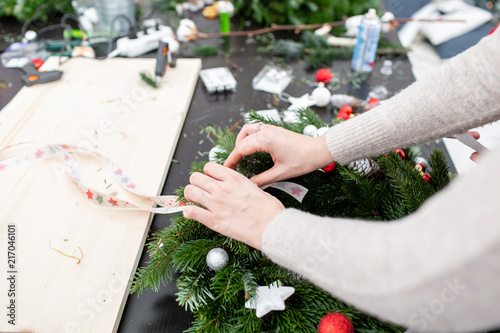woman tying a bow ribbon decorated a christmas wreath attaches toys and decor with - How To Tie Decorative Bows For Christmas Decor woman tying a bow ribbon decorated a christmas wreath attaches toys and decor with - How To Tie Decorative Bows For Christmas Decor