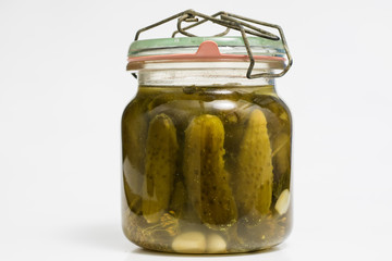 Vegetables in jars prepared for the winter. Tasty preserves on a white kitchen table.
