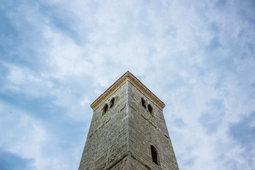 Fototapeta na wymiar old medieval tower architecture concept on rainy cloud sky background with empty space for copy or text