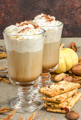 Pumpkin spice latte, hot coffee drink with whipped cream decorated with autumn leaves