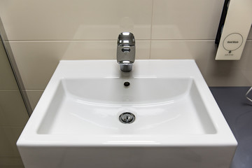 Classic modern white washbasins with chrome water tap and soap holder