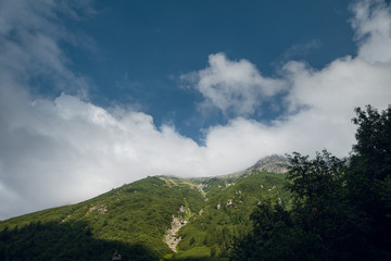 Fototapeta premium Beautiful view of green hills and mountain peaks with blue sky and white clouds. High Tatras, Zakopane. Poland