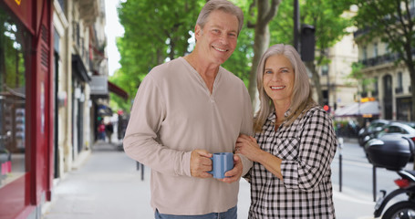 Obraz premium Loving old white couple stands happily on a Paris sidewalk