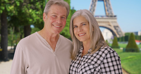 Senior Caucasian couple stand together in front of Eiffel Tower