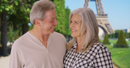 Senior Caucasian couple stand together in front of Eiffel Tower