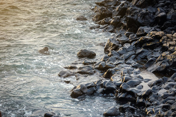 Frozen volcanic lava closeup thousands of years after the eruption on background of ocean