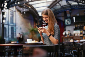 Woman With Mobile Phone In Cafe