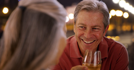 Elderly Caucasian couple have conversation over wine at restaurant 