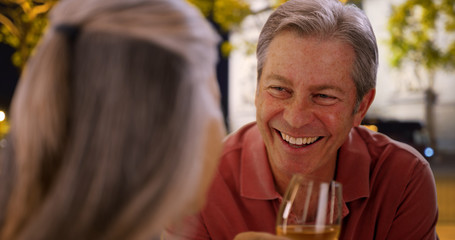 Mature Caucasian male chats with female at restaurant over wine