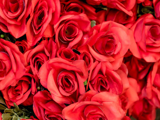 A bouquet of artificial red roses closeup background. Selective focus.