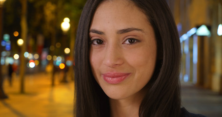 Obraz premium Beautiful Latina female stands on Champs Elysees avenue smiling at camera