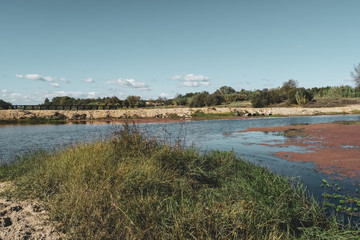 View across Sorraia river in Santa Justa, Coruche Santarem, Portugal. Taken on a hot sunny afternoon with some big white clouds. bridge to the bottom.