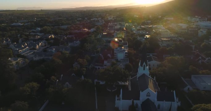 Drone fly over of Stellenbosch town at sunset. back tracking from Church revealing the city in 4K and 60fps.