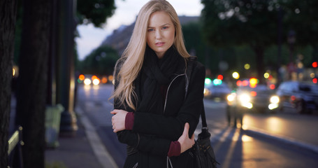 Fototapeta premium Stunning modern white woman poses for camera while standing on sidewalk