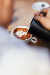 Coffee Art In Cup. Closeup Of Hands Making Latte Art 