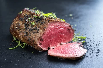 Foto auf Glas Traditional barbecue dry aged wagyu fillet steak with herb and spice marinated as closeup on a black board © HLPhoto