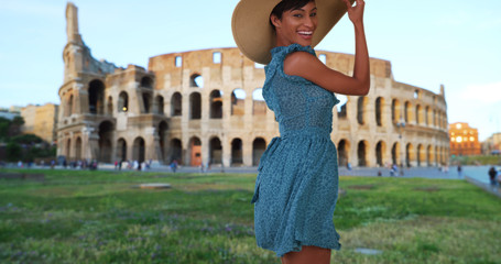 Fototapeta premium Young attractive African-American female posing happily near Roman Colosseum