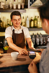 Customer Paying With Mobile Phone In Cafe