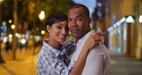 Happy ethnic boyfriend and girlfriend romantically posing on Champs-Elysees